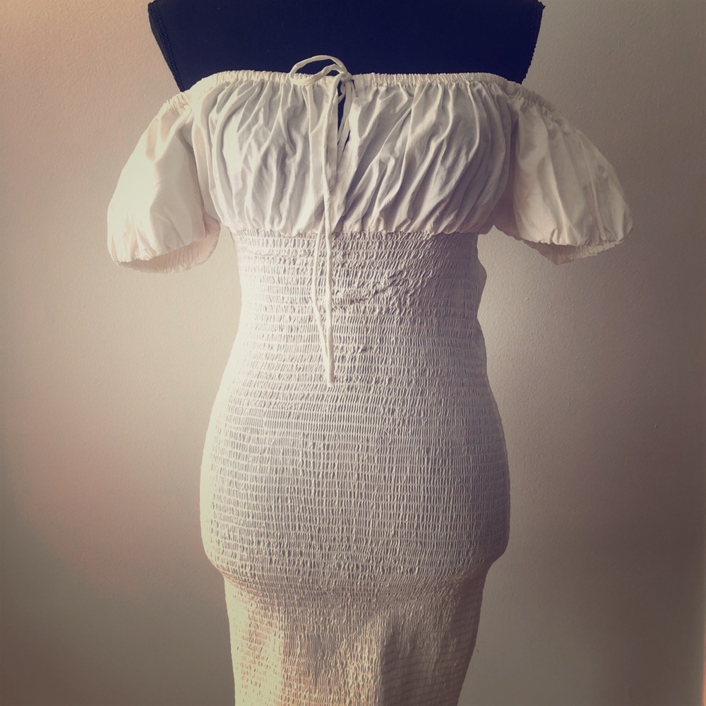 Off shoulder white body fitting dress.